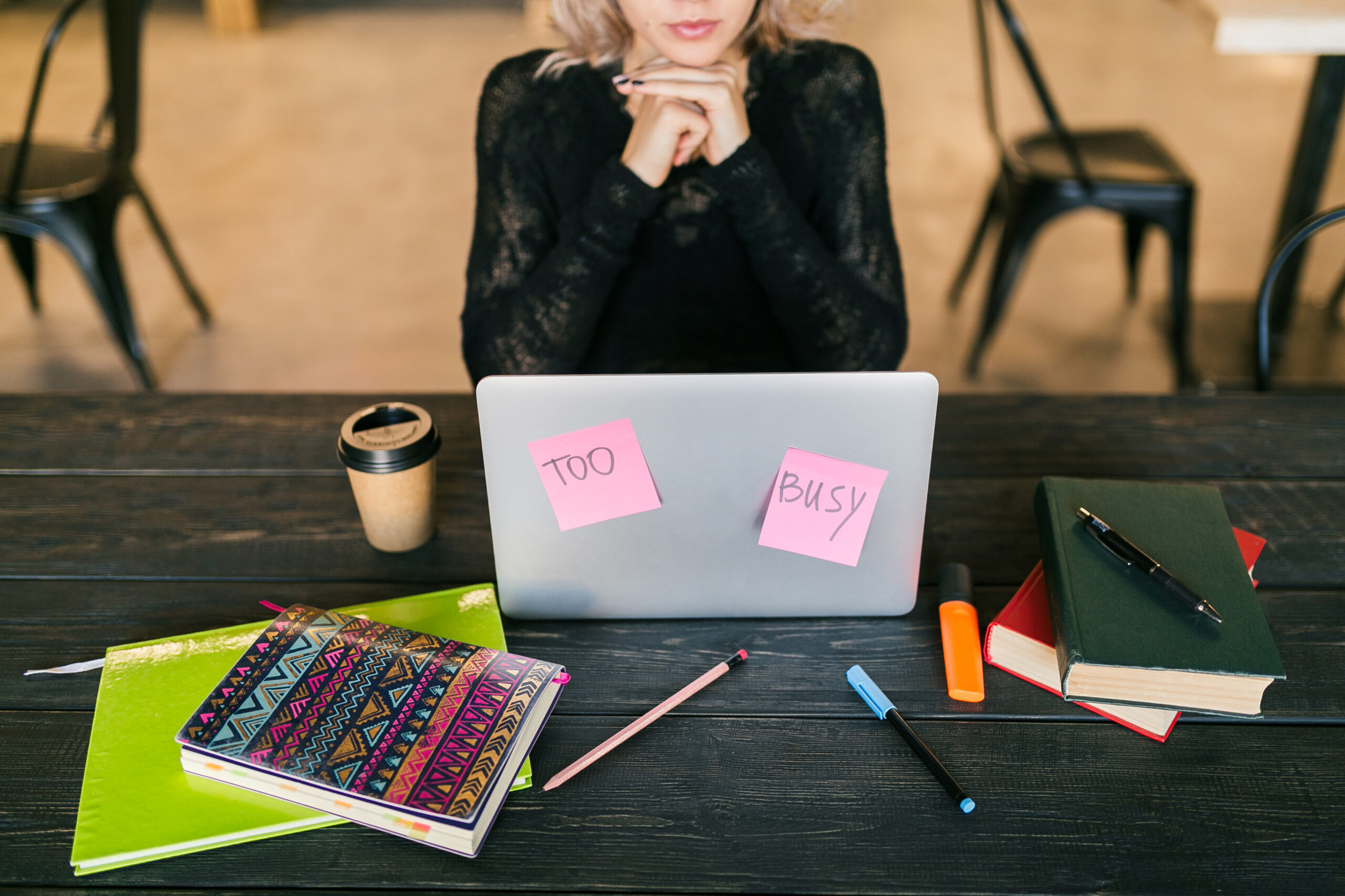 young pretty busy woman working on laptop, busy paper stickers, consentration, student in class room, top view on table with stationery, do not disturb